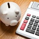 white piggy bank beside desk calculator