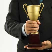 Headless man in suit holding gold trophy