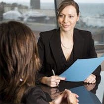 Two women in interview situation - white collar office