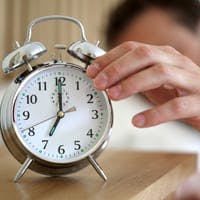 man reaching for clock