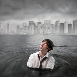 Man drowning in dark water, with city scape behind him