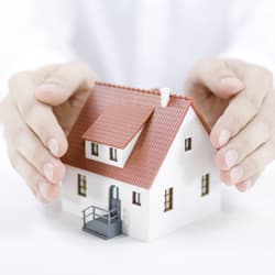 Woman cupping her hands around a miniature house