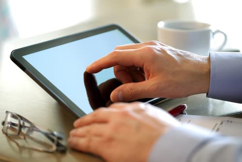 man using tablet at desk