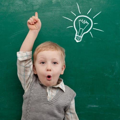 little boy in front of chalkboard with light globe