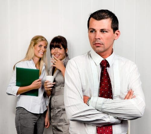 two women talking behind man's back