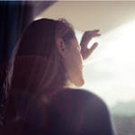 woman looking out rainy window